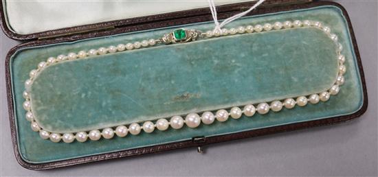 A single strand graduated cultured pearl necklace with an emerald and diamond set white metal clasp, approx. 35cm.